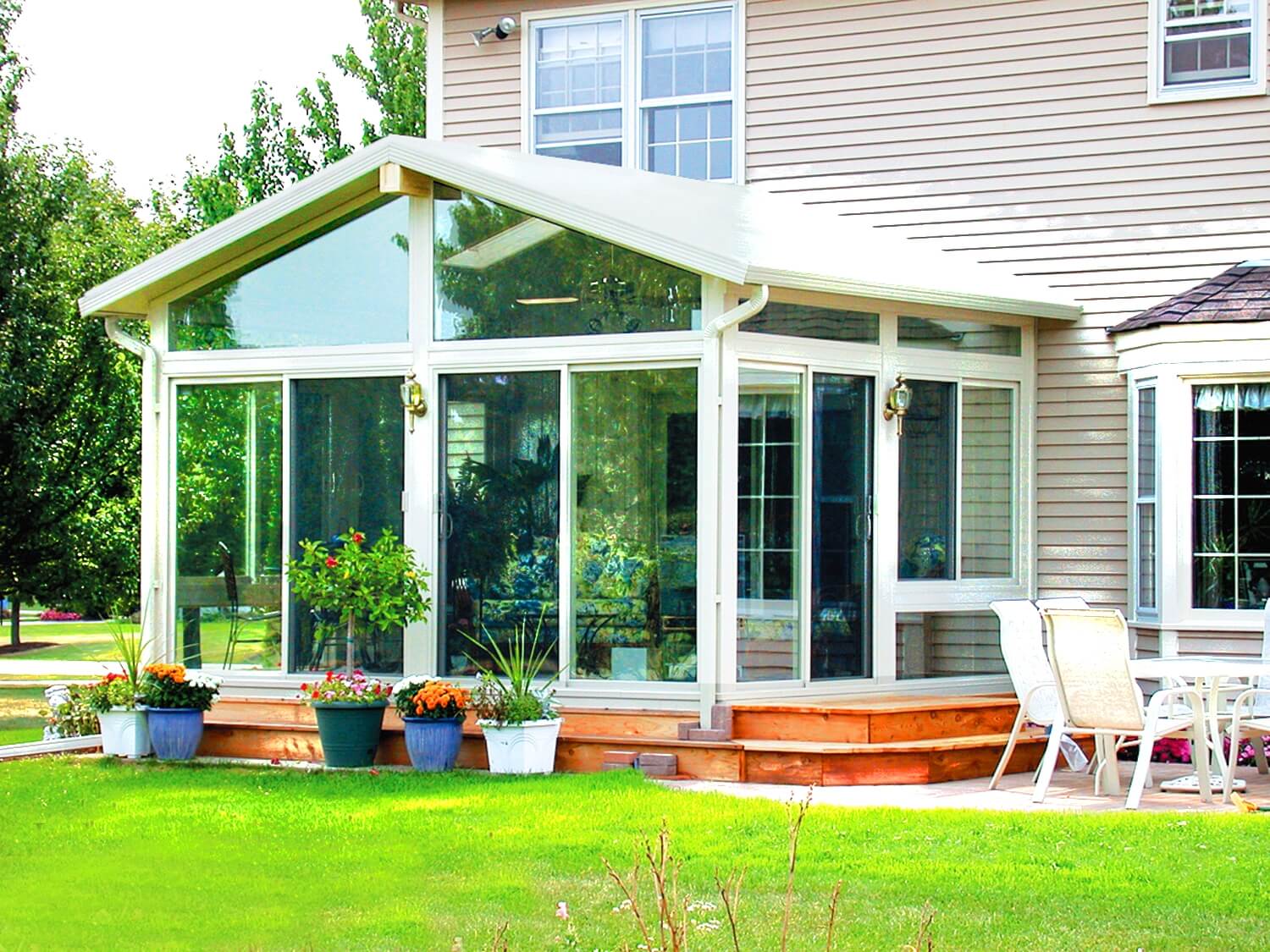 sunroom glass enclosure with wooden deck